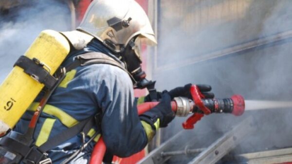 Πυροσβέστης με ειδική στολή εν ώρα εργασίας ρίχνει νερό σε πύρινο μέτωπο