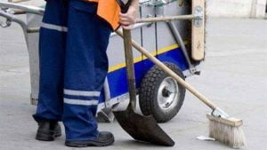 ΑΣΕΠ Προσλήψεις: Εργάτης καθαριότητας με ειδική στολή του δήμου, κρατά σκούπα και φαράσι - ειδικός κάδος απορριμμάτων