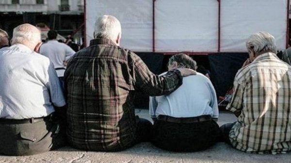 Συνταξιοδότηση: Άνδρες έξω από κτίριο κοιτούν έγγραφα κολλημένα στο τζάμι