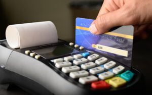 Πληρωμή με κάρτα σε POS. Χέρι καρτά πιστωτική κάρτα. Απόδειξη βγαίνει από το POS
