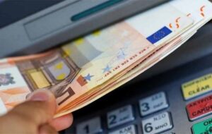 χέρι παίρνει από θυρίδα ΑΤΜ χαρτονομίσματα των 50 ευρώ