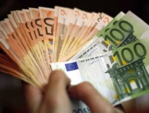 χέρια κρατάνε πολλά χαρτονομίσματα των 50 και 100 ευρώ