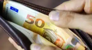 Κάποιος κρατά ένα πορτοφόλι ανοιχτό με χαρτονομίσματα των 50 ευρώ..