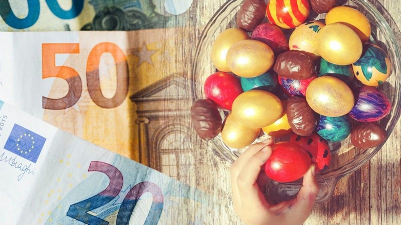 πασχαλινά αυγά βρίσκονται σε μια γυάλινη πιατέλα δίπλα βρίσκονται χαρτονομίσματα των 20 και 50 ευρώ