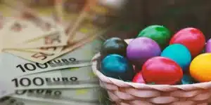 πασχαλινό καλάθι με κοκκινα πράσινα κιτρινα και μπλε αυγά βρίσκεται πάνω σε χαρτονομίσματα των 50 και εκατό ευρώ