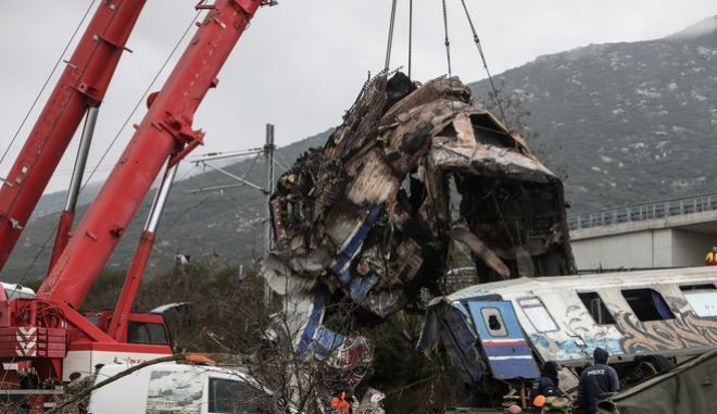 σωστικά συνεργεία μετακινούν κομμάτια από το κατεστραμμένο βαγόνι μετά το δυστύχημα στα Τέμπη