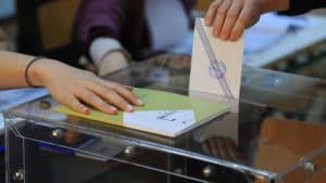 Χέρι που ρίχνει στην κάλπη φάκελο με την ψήφο του σε εκλογές
