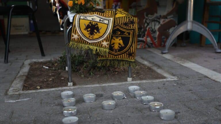 Μνημείο με κασκόλ και κεριά στο σχήμα του αρχικού γράμματος του άτυχου Μιχάλη Κατσούρη που σκοτώθηκε στα επεισόδια της Νέας Φιλαδέλφειας