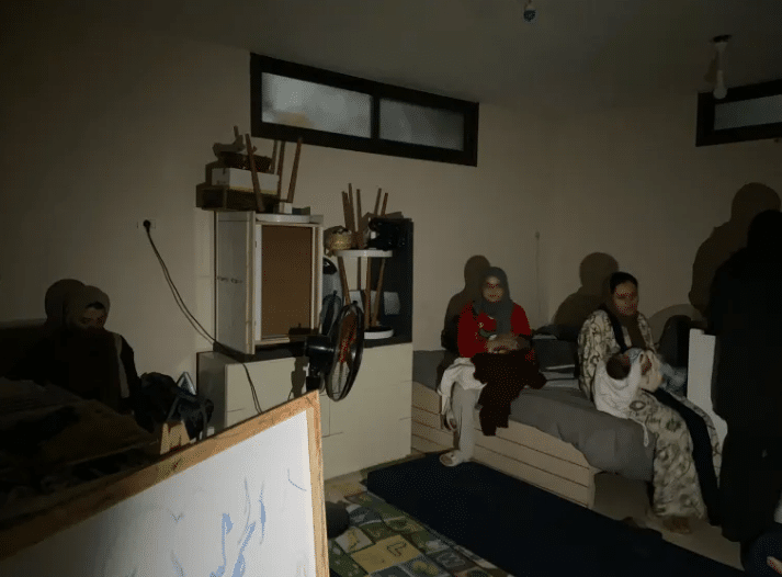 Maram’s family huddled together in the dark [Maram Humaid/Al Jazeera]
