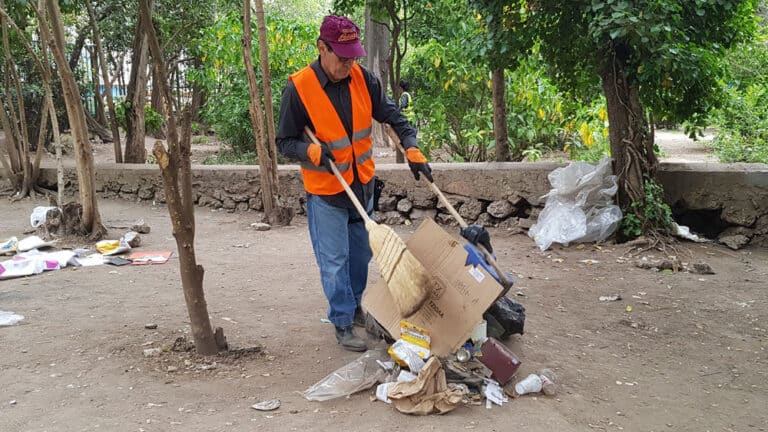 εργάτης καθαριότητας καθαρίζει ένα πάρκο