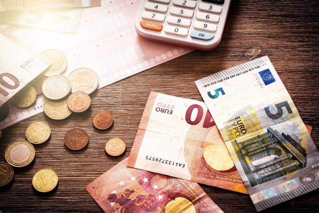 Euro banknotes and coins with bills to pay\. Finances and budget concept