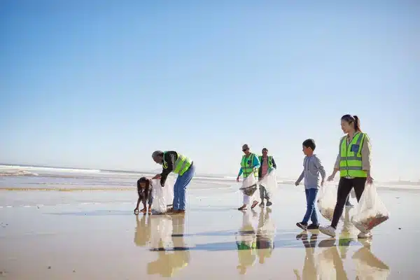 depositphotos 250560156 stock photo volunteers cleaning litter wet sand