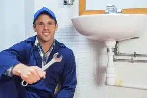 depositphotos 36168355 stock photo happy plumber holding wrench sitting