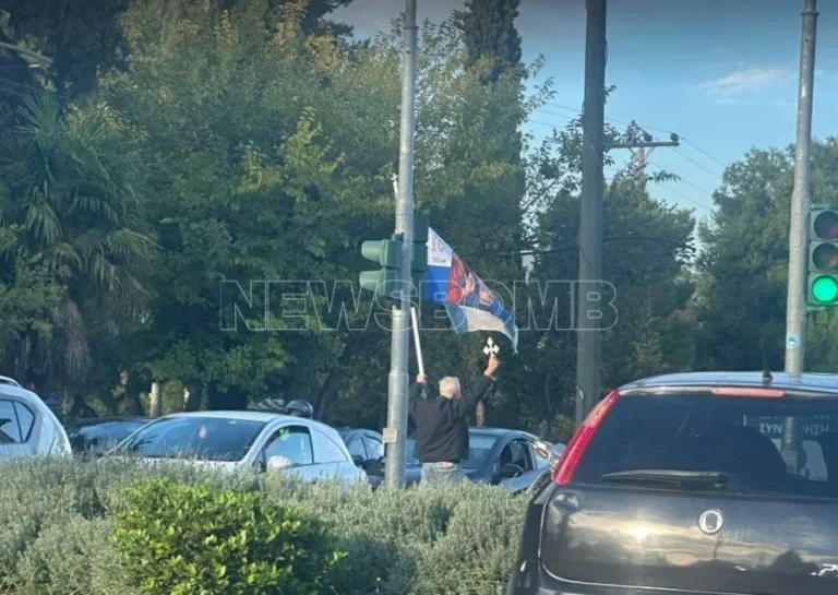 Κηφισίας: Άνδρας περπατάει κρατώντας ελληνική σημαία με εικόνα του Ιησού